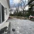 Residential patio and driveway area paved with interlocking concrete pavers, showcasing a popular paving material option for homeowners.