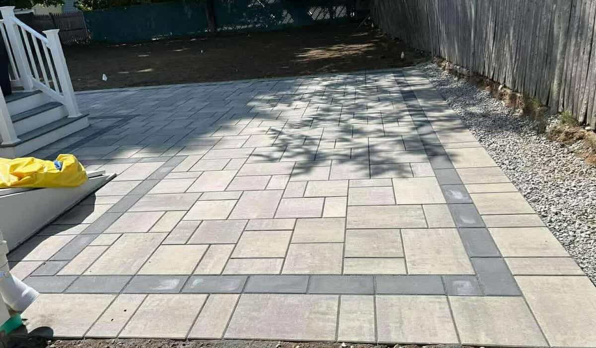 The evolution of paving materials from cobblestones to modern concrete pavers shown in a finished paved patio surface