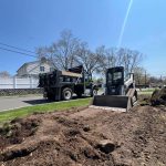 step by step process professional paving contractor site preparation Professional paving contractor performing site preparation and grading work with skid steer and dump truck before asphalt paving
