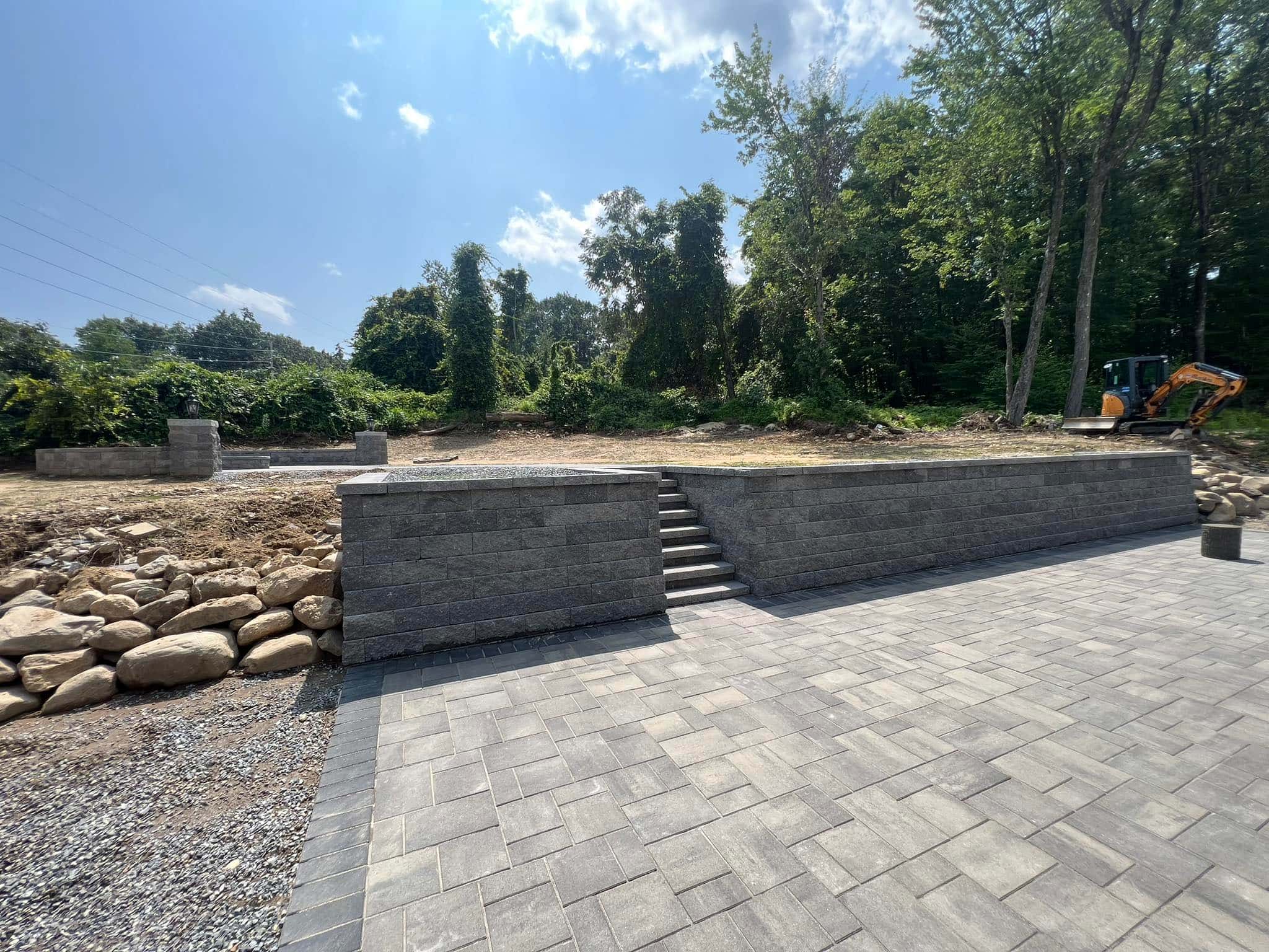 newly paved driveway with retaining wall showing ideal weather for paving contractor work