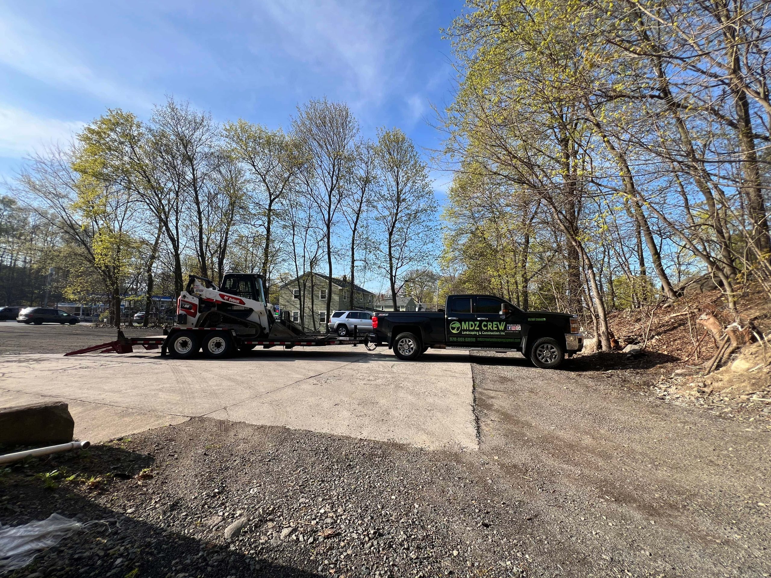 when to call a paving contractor truck with skid steer preparing driveway for paving work
