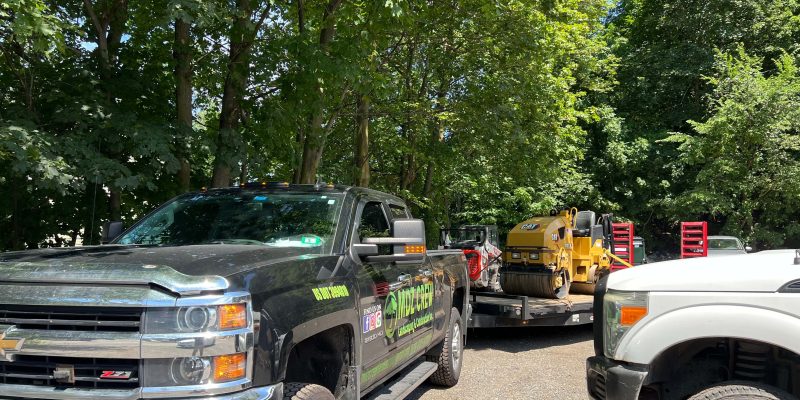 Professional licensed paving contractor truck and paving equipment on residential job site