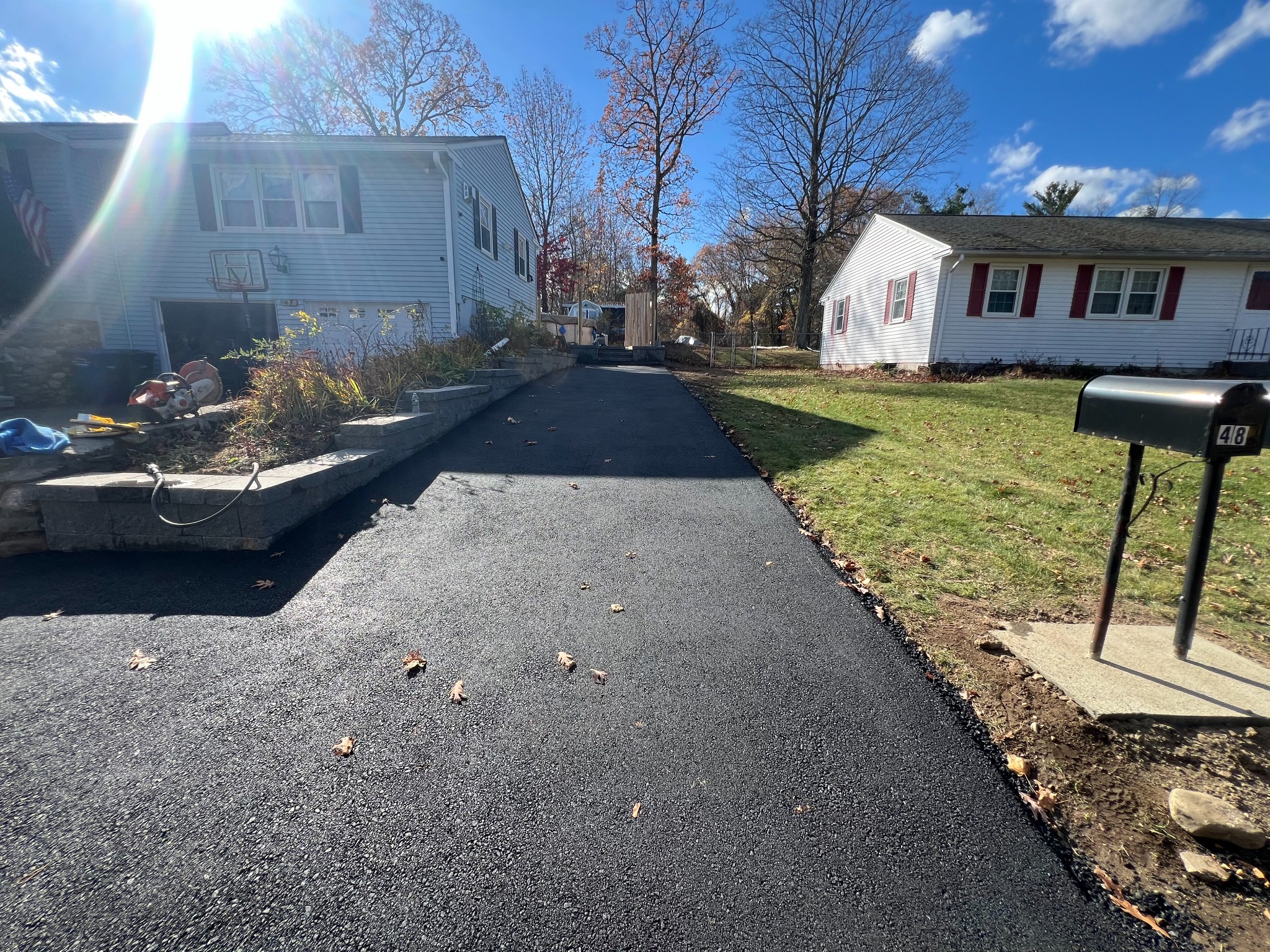 Freshly paved residential asphalt driveway completed by MDZ Crew Landscaping with professional driveway paving services.