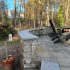 Custom stone patio with curved seating wall, granite caps, and outdoor dining area by MDZ Crew Landscaping & Paving Inc.