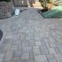 New permeable interlocking paver patio installation with decorative border and retaining wall by MDZ Crew Landscaping & Paving Inc.