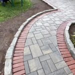 curved paver walkway brick border Curved paver walkway with brick border and natural stone edging beside landscaped planting beds