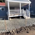 paver patio base preparation Paver patio base preparation with compacted stone aggregate around a residential porch