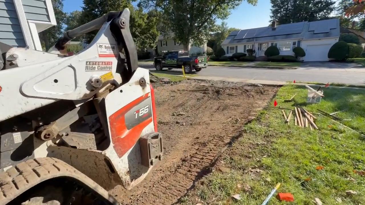 Residential excavation for patio installation using a compact skid steer to prepare a backyard