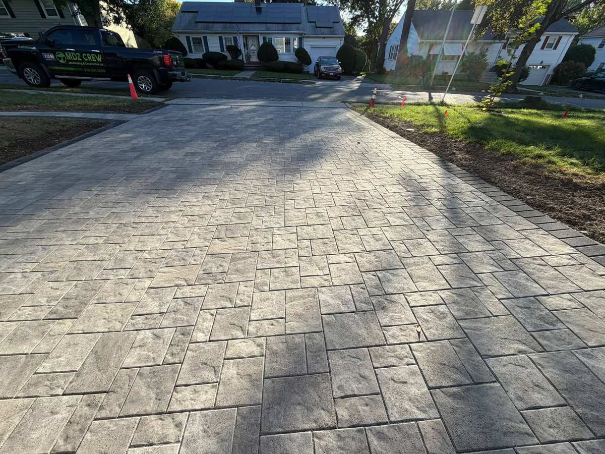 Interlocking paver driveway with landscaped planting beds and lawn in Massachusetts